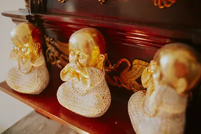 Drie gouden boeddha's op een plank in een kamer bij Ommij Healing Centre.